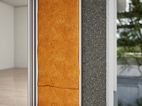 Nahaufnahme eines Wandquerschnitts mit oranger Dämmung und grauer Schicht mit gelben Punkten