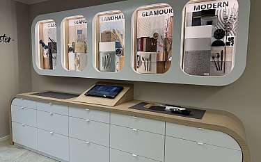 Ausstellung mit Küchenfronten, Arbeitsplatten und Materialmustern in einer Einrichtungsgalerie.