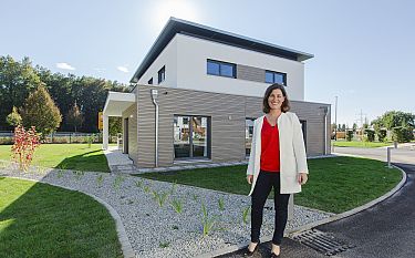 Frau vor modernem Haus