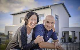 Lächelndes Paar vor Haus